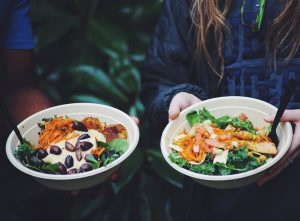 two bowls of food being held by students