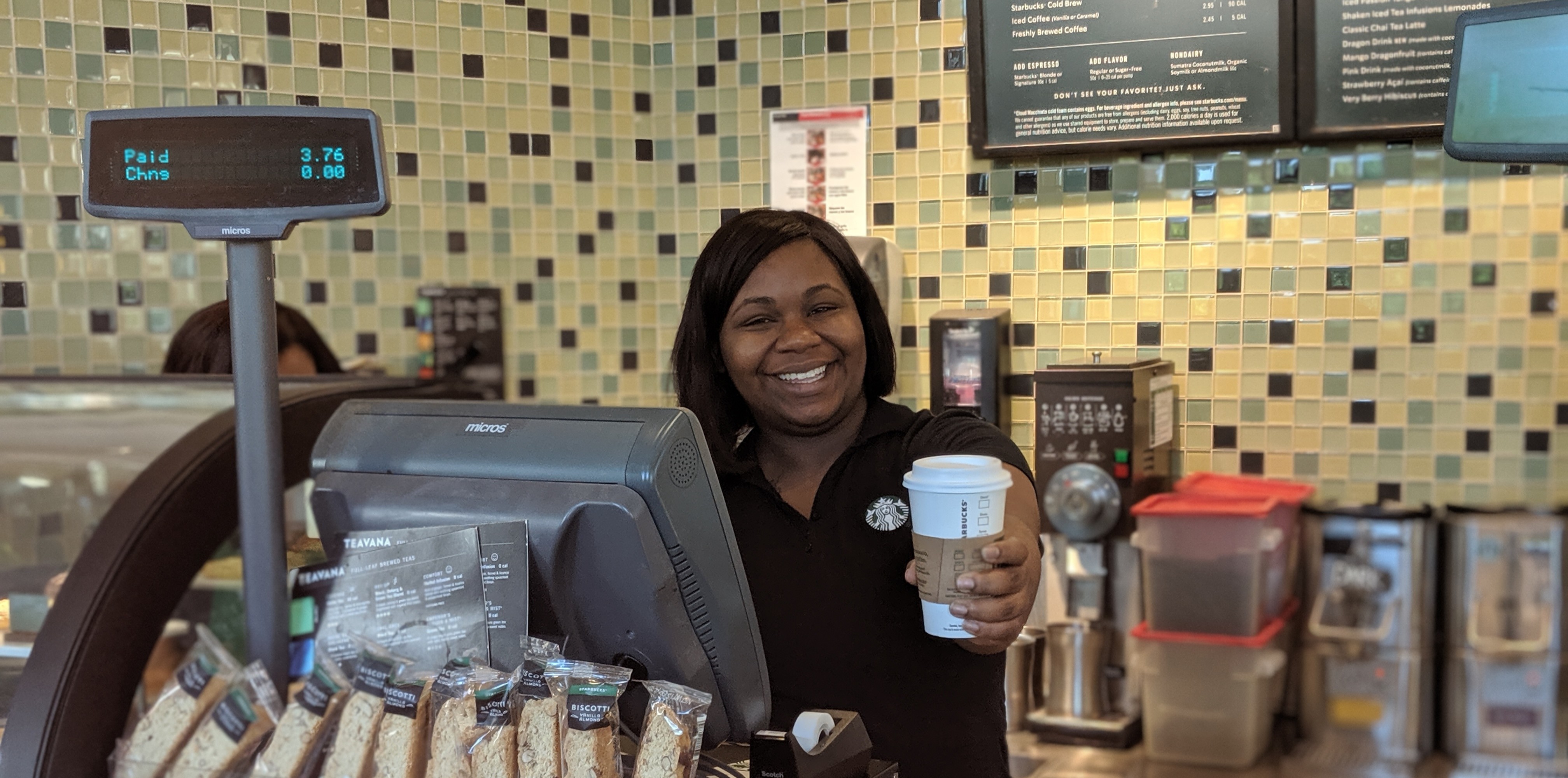 cashier offering a cup of coffee